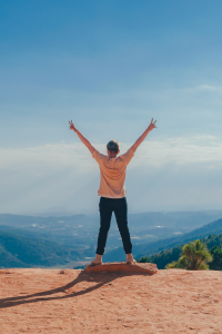 person celebrating wins on mountain